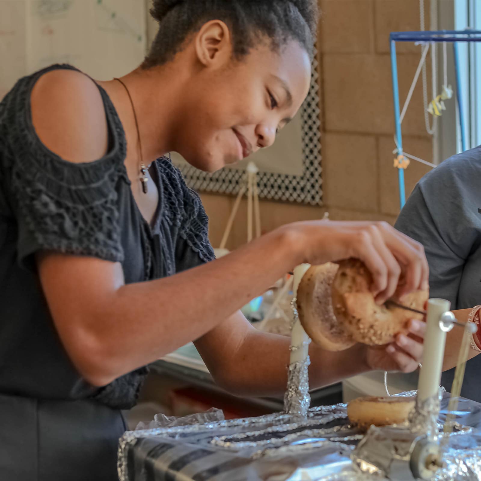 A middle school student builds a machine involving a bagel.